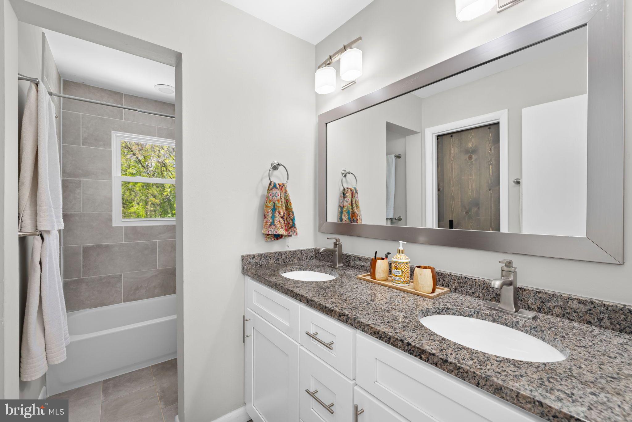 6502 Haystack Road Alexandria, VA 22310 - Photo 16 of 30 a bathroom with a granite countertop sink tub and mirror