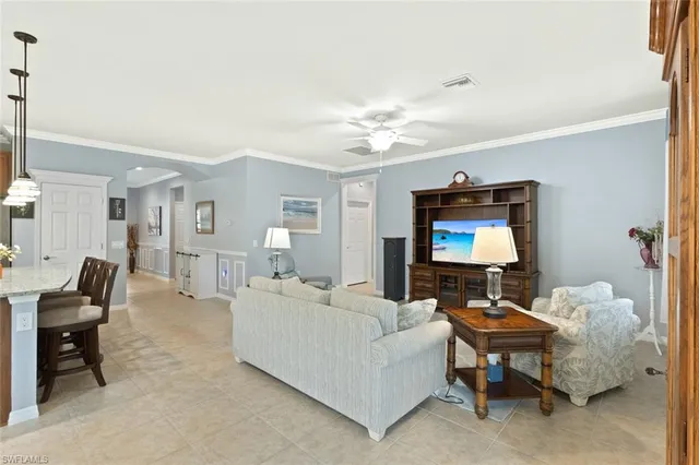 a living room with furniture a ceiling fan and a flat screen tv