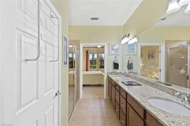 a spacious bathroom with a granite countertop sink a mirror and a shower
