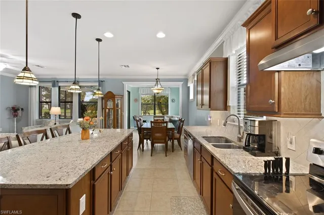 a kitchen with stainless steel appliances granite countertop sink stove and wooden cabinets