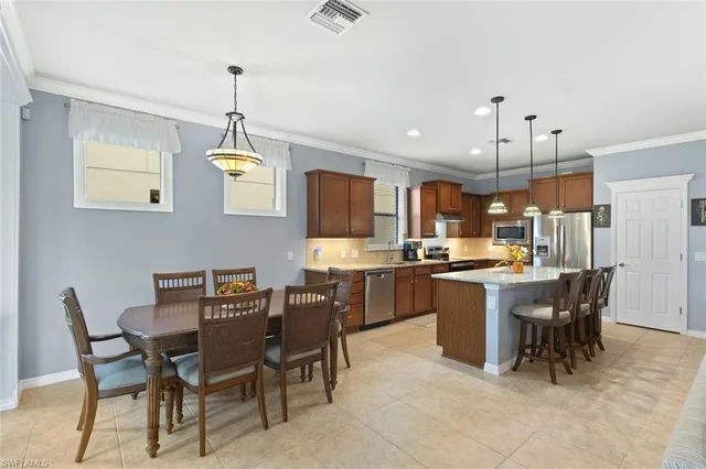 a dining area with a table chairs and a kitchen view
