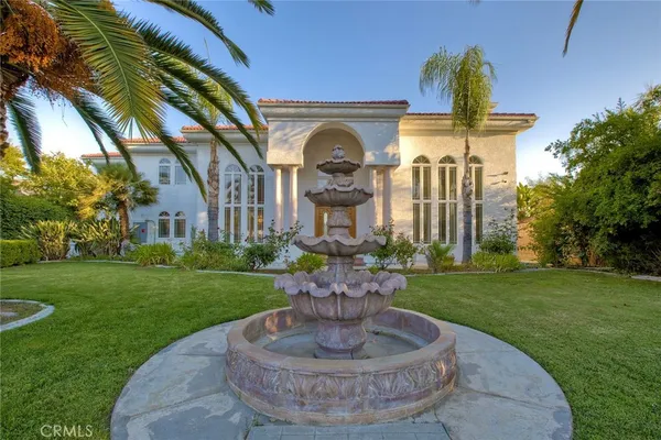 a view of a house with a fountain and a garden