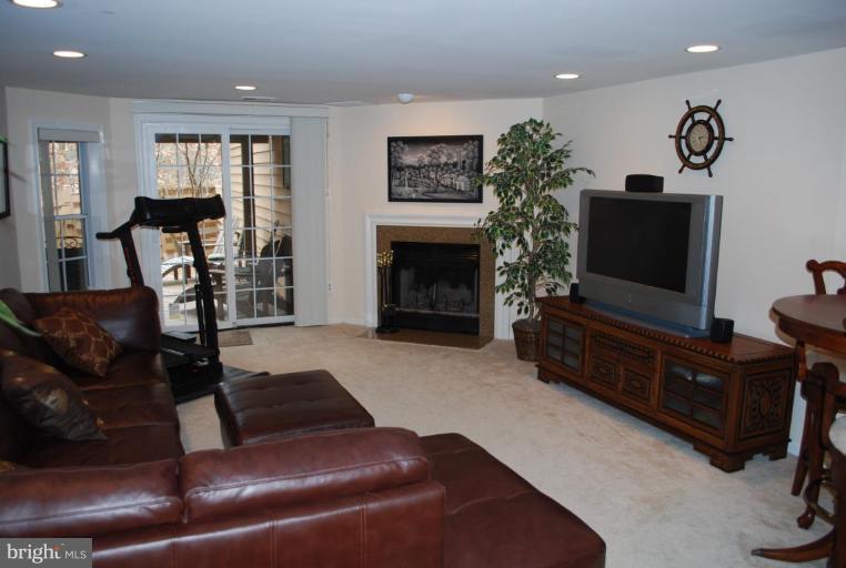 1532 Deer Point Way Reston, VA 20194 - Photo 15 of 19 a living room with furniture a flat screen tv and a fireplace
