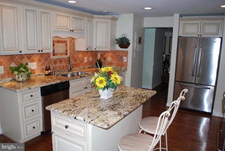 1532 Deer Point Way Reston, VA 20194 - Photo 7 of 19 a kitchen with stainless steel appliances granite countertop a refrigerator stove and white cabinets
