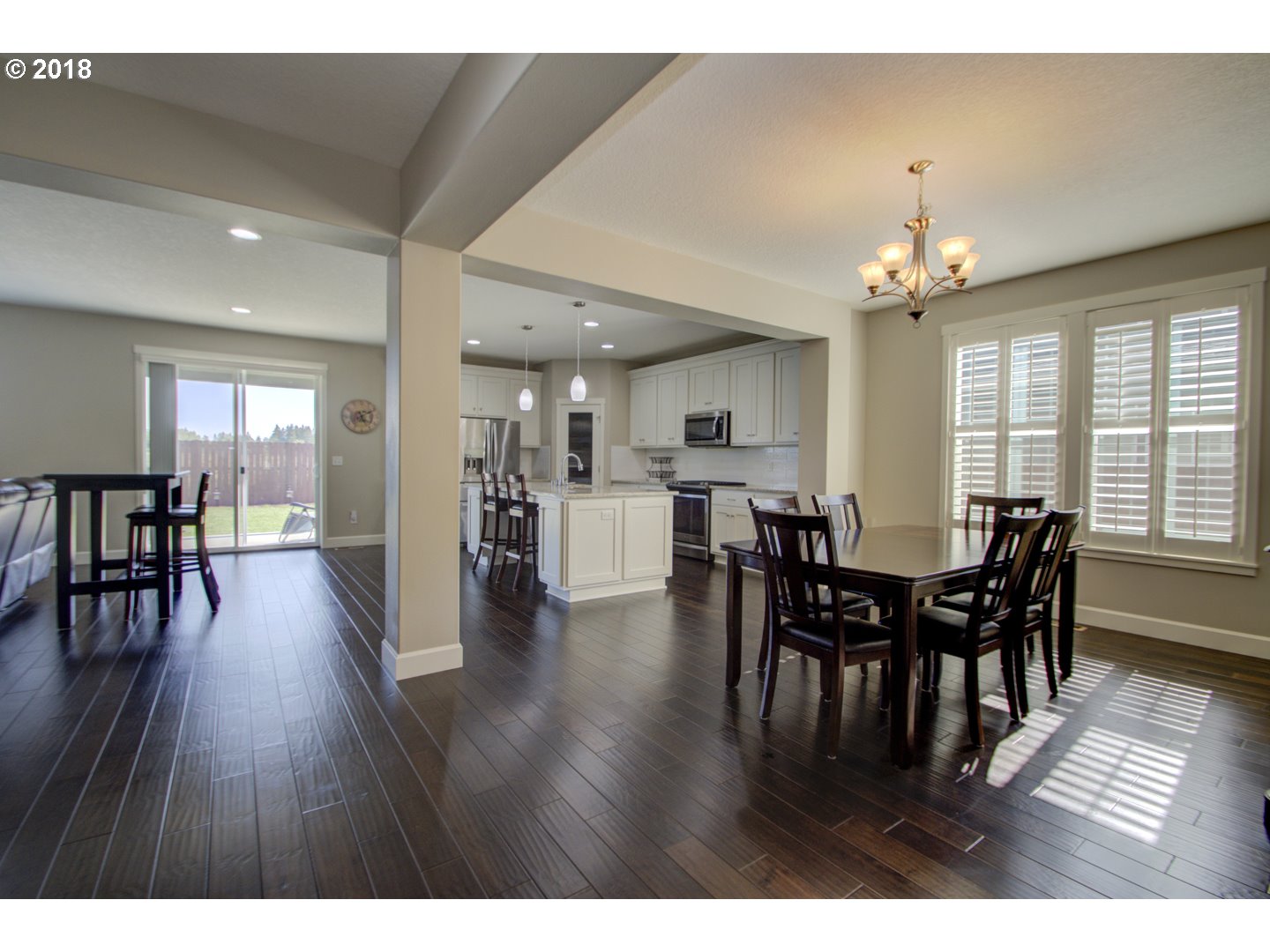 4821 North 6th Street Ridgefield, WA 98642 - Photo 5 of 29 a view of a dining room and livingroom with furniture wooden floor a rug a chandelier