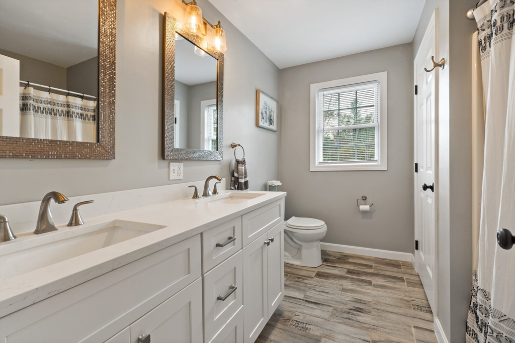 19 Cedar Street Rehoboth, MA 02769 - Photo 29 of 37 a bathroom with a double vanity sink a mirror and a toilet