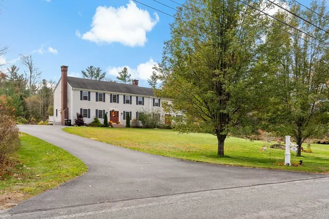 a view of a big house with a big yard and large trees