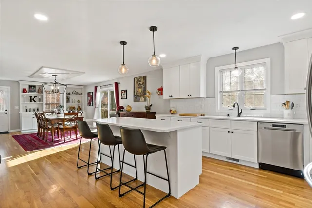 a kitchen with a dining table chairs sink and cabinets