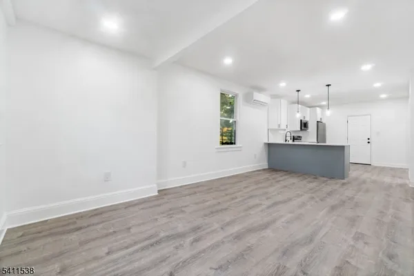 a kitchen with stainless steel appliances a sink a stove a refrigerator cabinets and a window