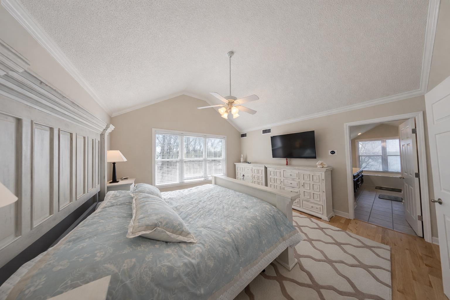30 Point Grand Court Savannah, TN 38372 - Photo 34 of 40 a spacious bedroom with a large bed a flat tv screen and a chandelier