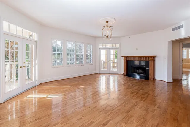 a view of empty room with wooden floor and fireplace