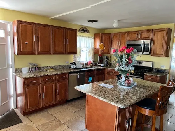 a kitchen with granite countertop kitchen island sink and cabinets
