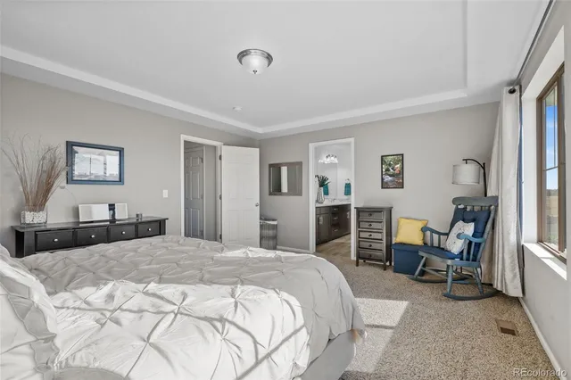 a spacious bedroom with a bed a table and chair