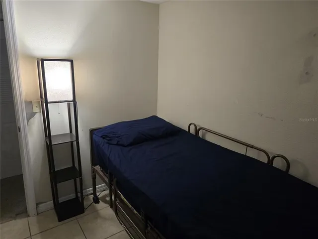 a bedroom with a bed and a window