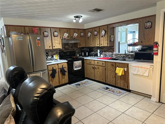 a kitchen with stainless steel appliances granite countertop a sink a stove and a refrigerator