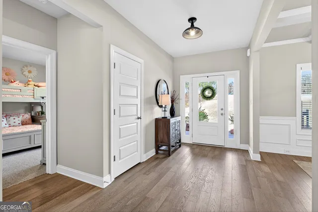a view of a hallway with wooden floor and furniture