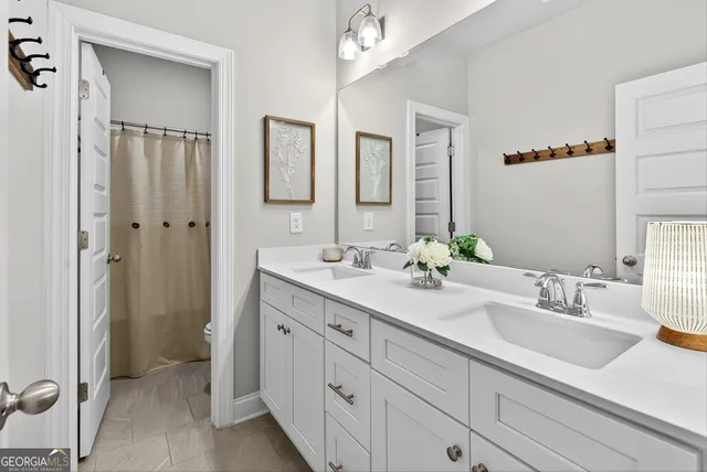 a bathroom with double sink and a mirror