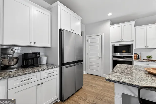 a kitchen with granite countertop a refrigerator sink and cabinets