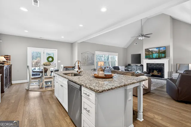 a kitchen with stainless steel appliances granite countertop sink stove and wooden floor