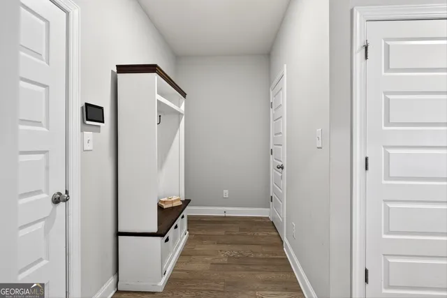a view of a hallway with wooden floor and staircase