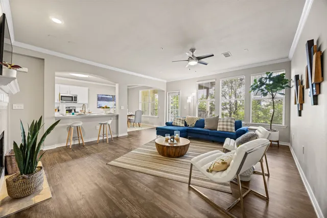 a living room with furniture potted plant and a large window