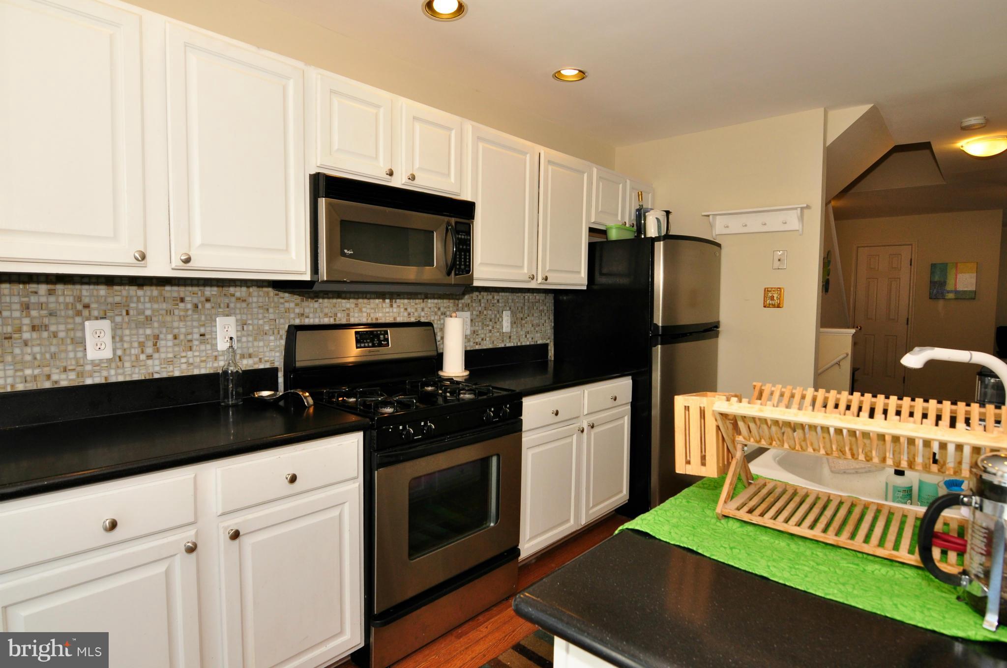 12095 Edgemere Circle Reston, VA 20190 - Photo 14 of 28 a kitchen with granite countertop a stove a sink and a microwave