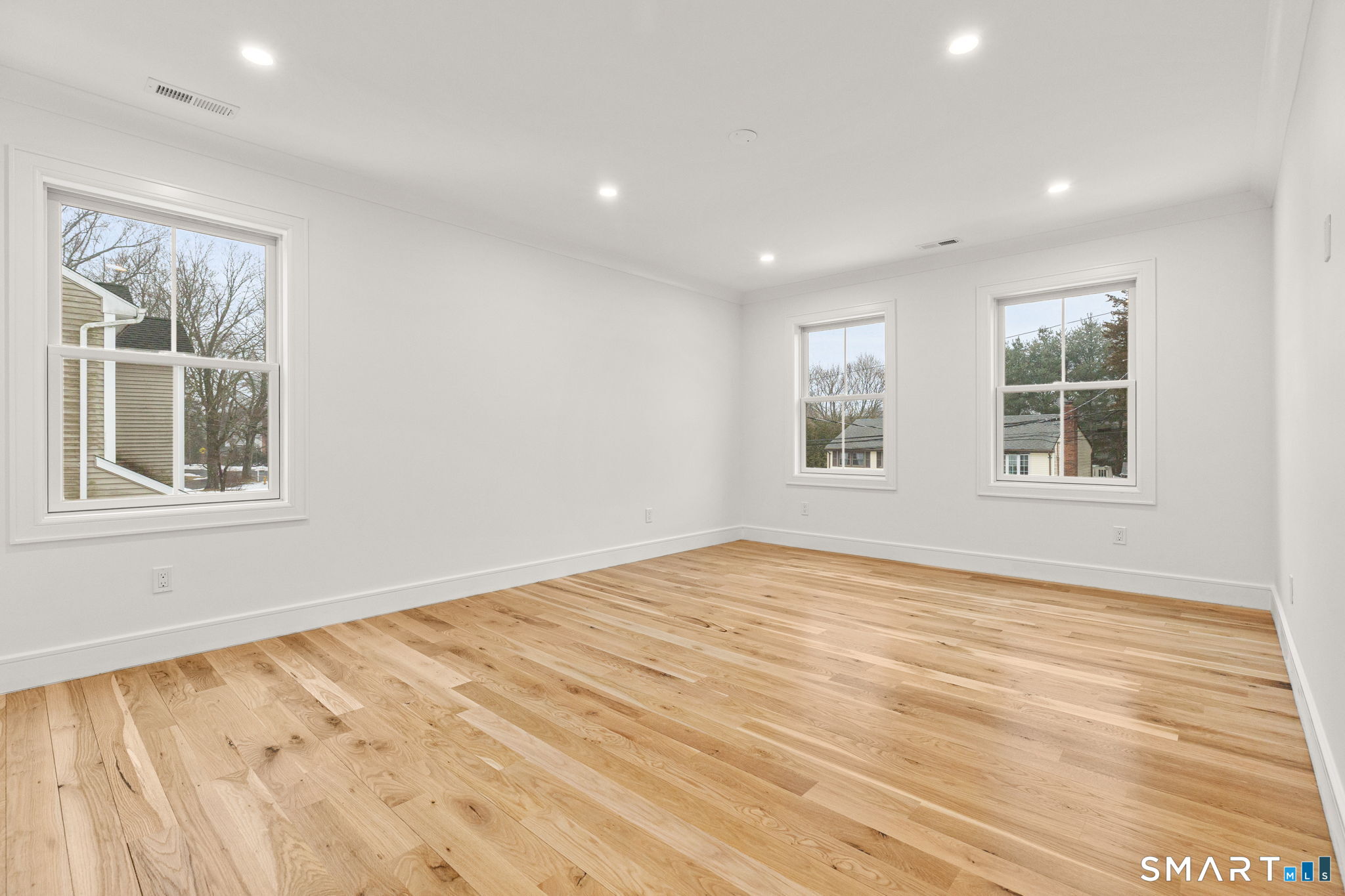 210 Pansy Road Fairfield, CT 06824 - Photo 16 of 26 a view of an empty room with a window and wooden floor