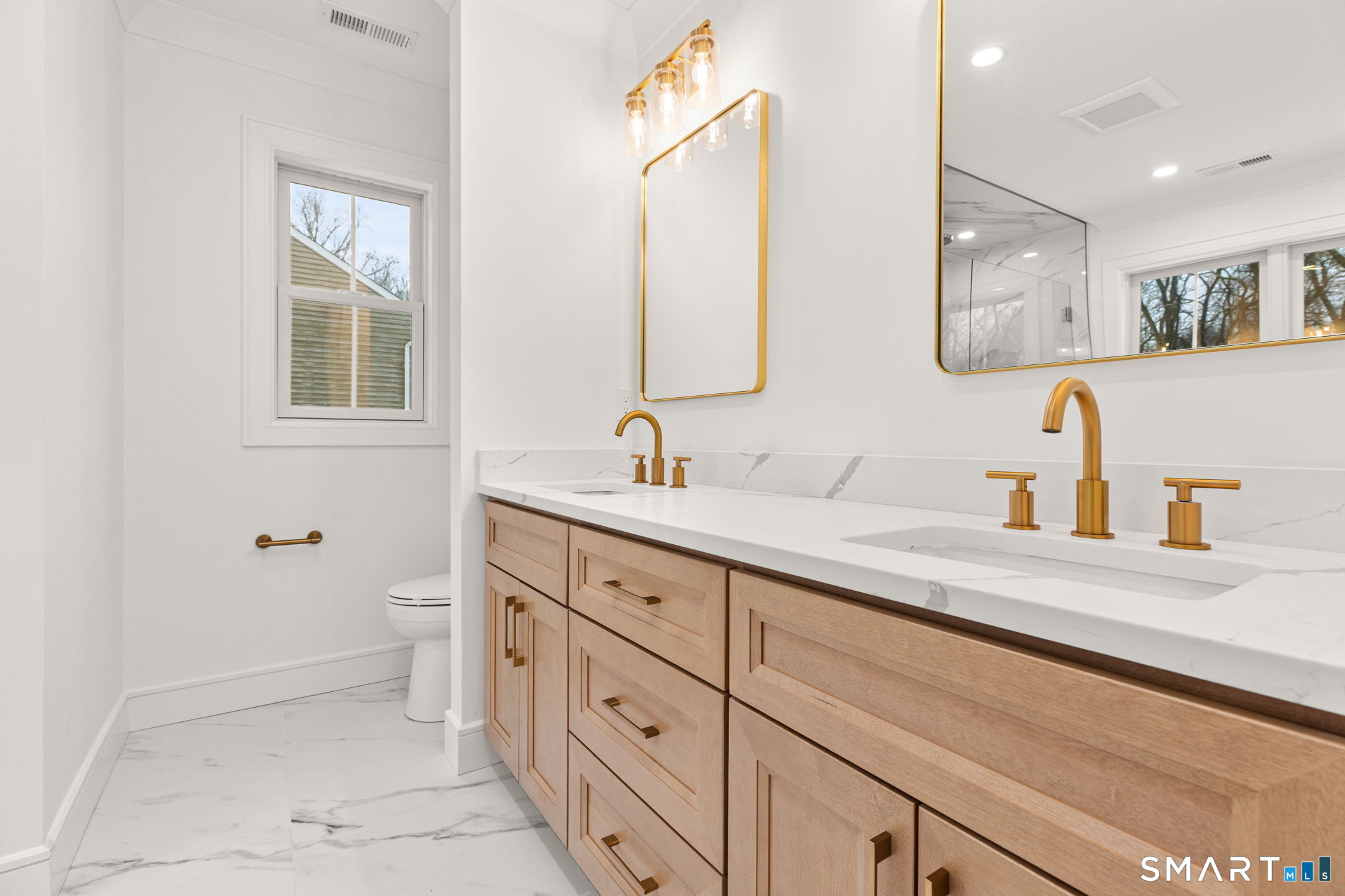 210 Pansy Road Fairfield, CT 06824 - Photo 18 of 26 a bathroom with a double vanity sink a mirror and a bathtub