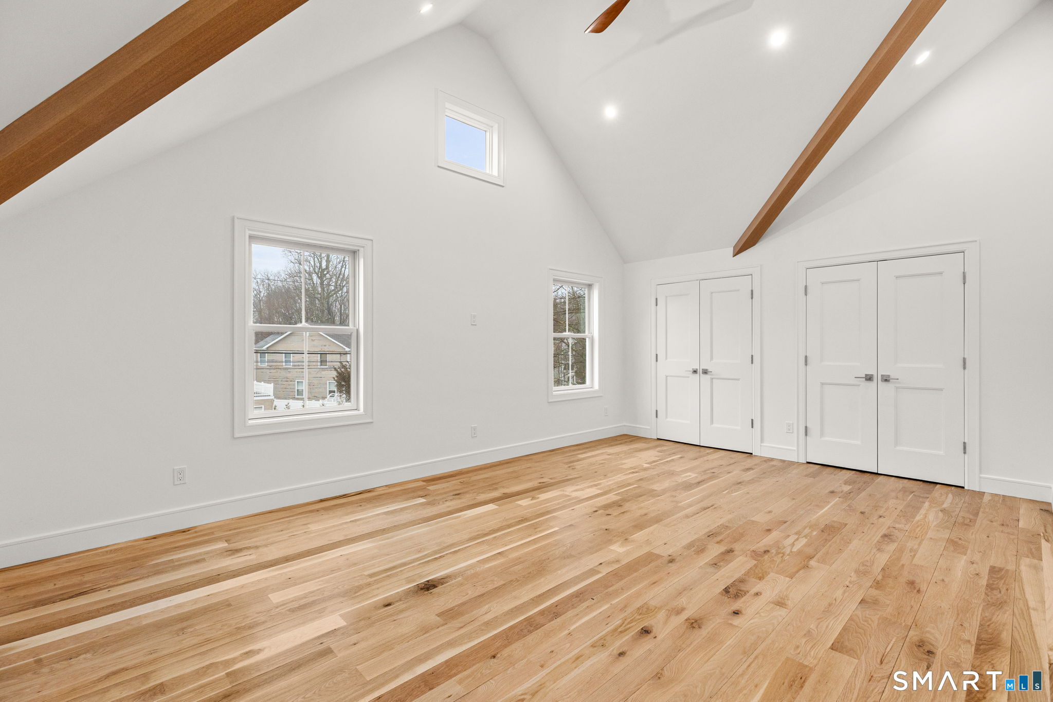 210 Pansy Road Fairfield, CT 06824 - Photo 20 of 26 an empty room with wooden floor and windows