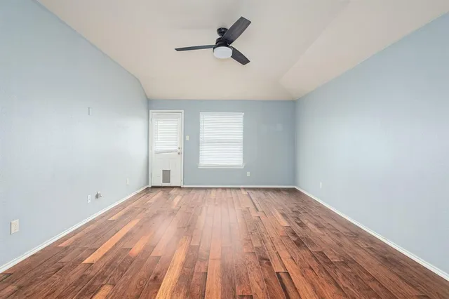 a view of a kitchen with a stove cabinets a ceiling fan and wooden floor