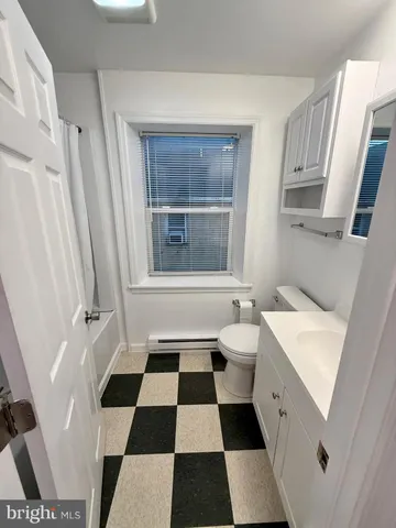 a bathroom with a black white checkered floor and a black white checkered floor with a chair
