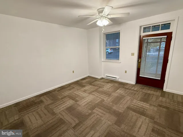 a view of empty room with window and ceiling fan
