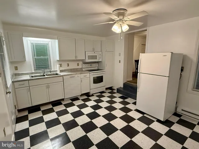 a kitchen with a checkered floor and a refrigerator a sink