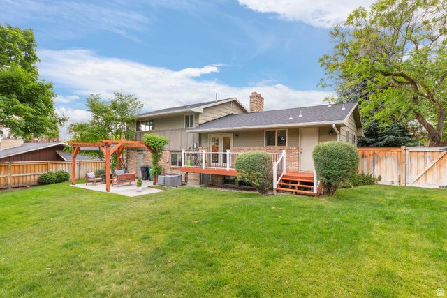 3320 Cherokee Lane Provo, UT 84604 - Photo 43 of 52 Expansive backyard featuring a lush lawn, a wood pergola over a concrete patio, a raised wood deck with white railings, a separate wood staircase, and a wood privacy fence