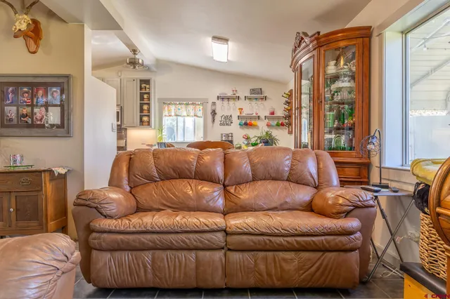 a living room with furniture a large window and a flat screen tv
