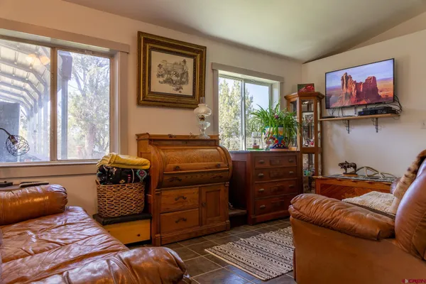 a bedroom with a bed and a large mirror next to a window
