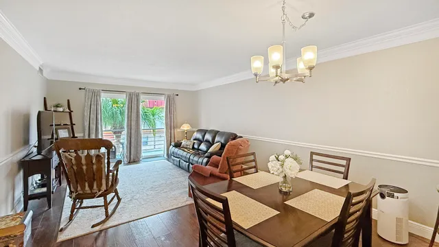 a view of a dining room with furniture a chandelier and wooden floor