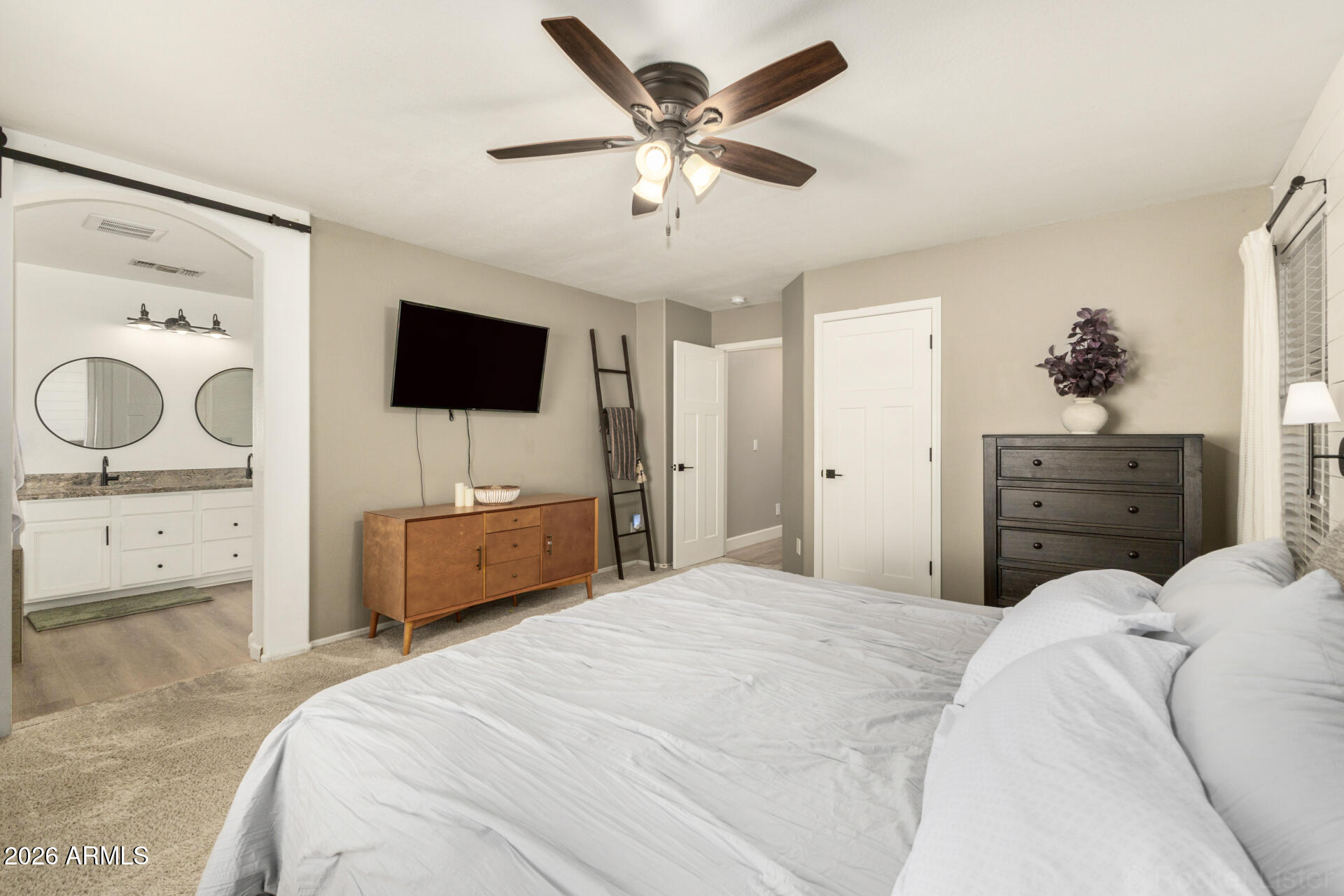 1736 East Robin Lane Gilbert, AZ 85296 - Photo 12 of 25 a bedroom with a bed a couches and a flat tv screen