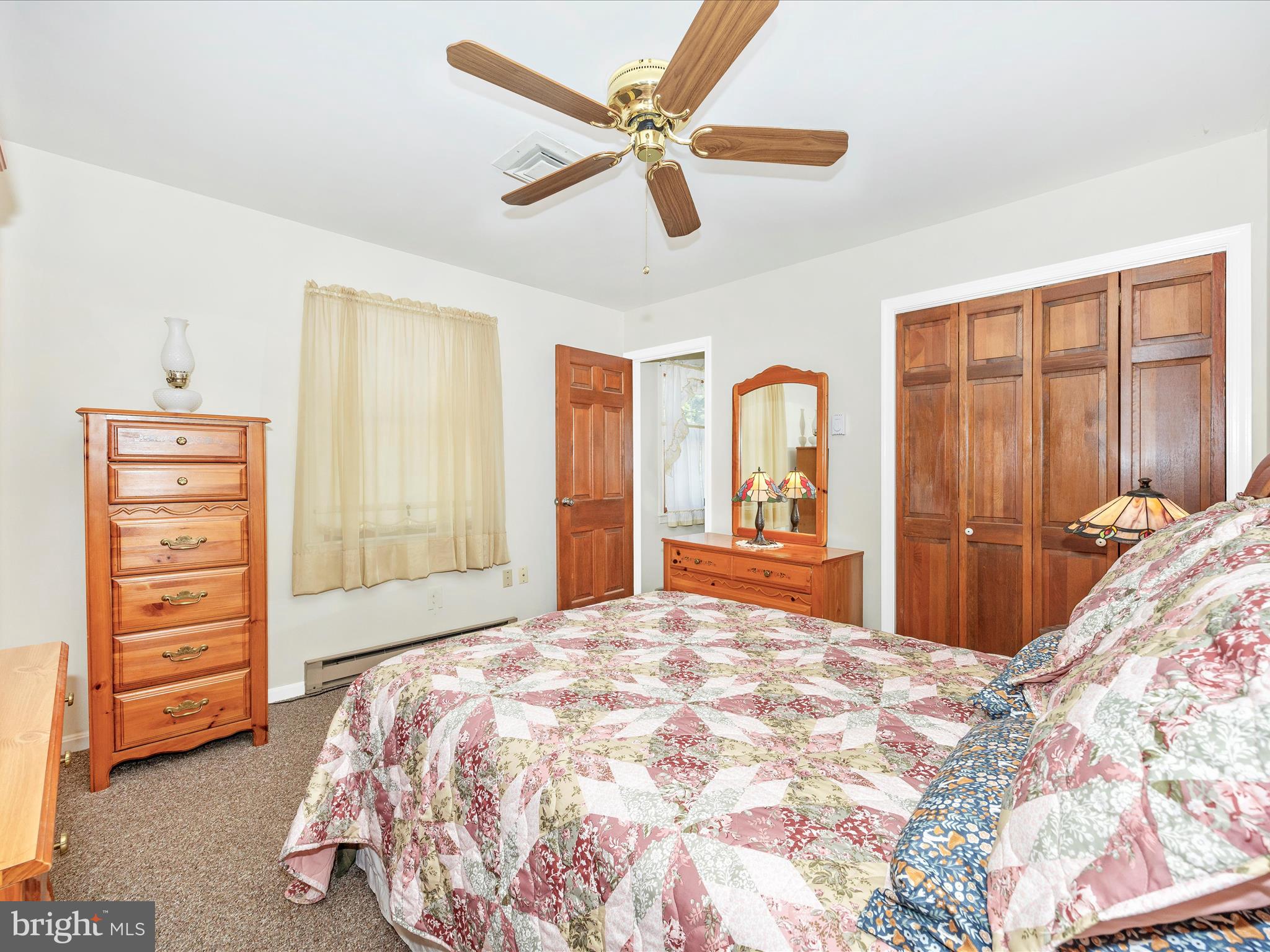 17515 Dr Bird Road Sandy Spring, MD 20860 - Photo 34 of 76 a bedroom with a large bed and dresser with mirror