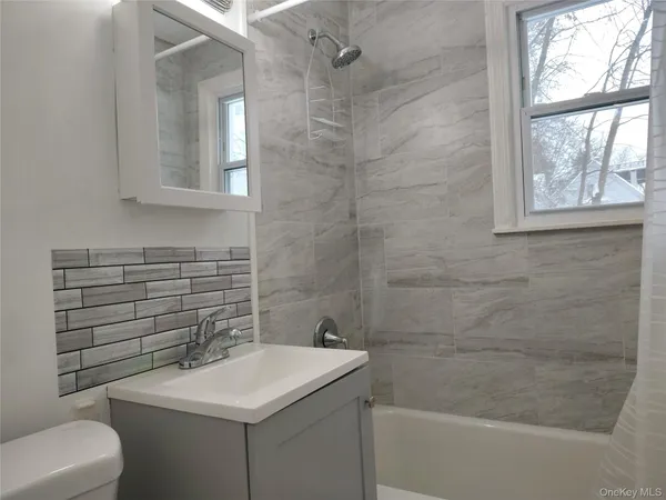 a bathroom with a sink toilet and window