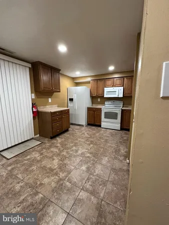 a view of kitchen with refrigerator cabinets and furniture