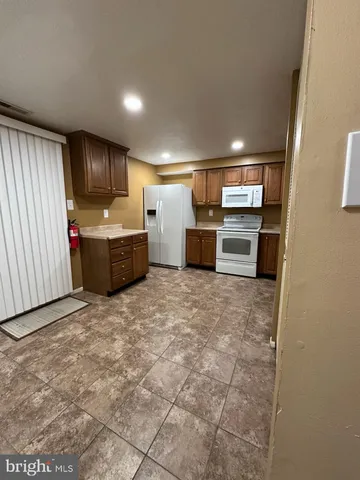 a view of kitchen with refrigerator cabinets and furniture