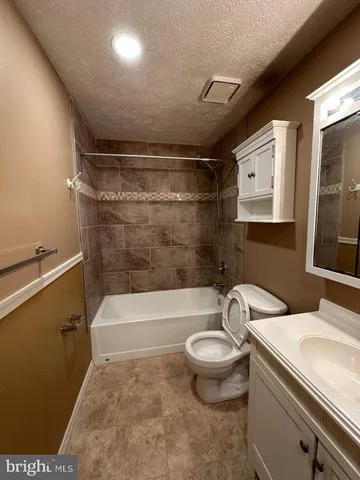 a bathroom with a sink a toilet and bathtub