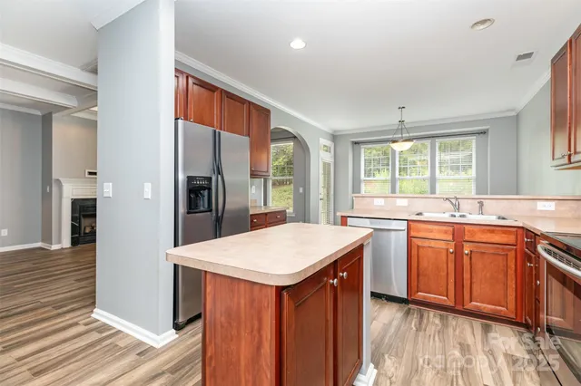 a kitchen with stainless steel appliances granite countertop refrigerator sink and wooden cabinets