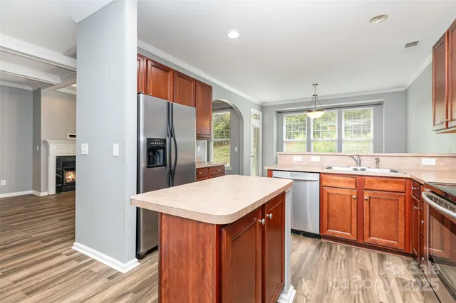 a kitchen with stainless steel appliances granite countertop refrigerator sink and cabinets