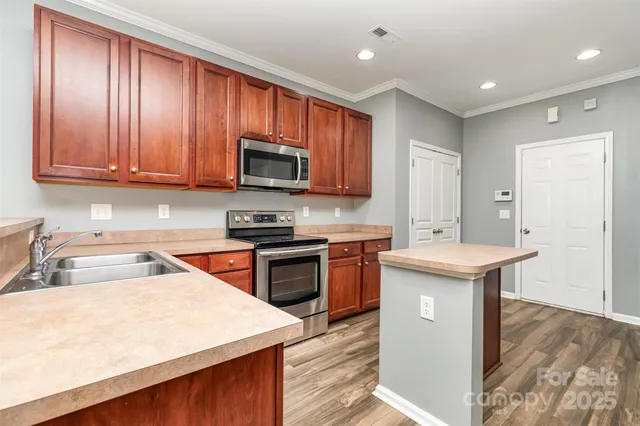 a kitchen with stainless steel appliances granite countertop a sink stove microwave and refrigerator