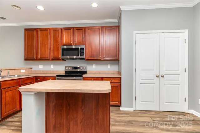 a kitchen with granite countertop wooden cabinets and a stove top oven