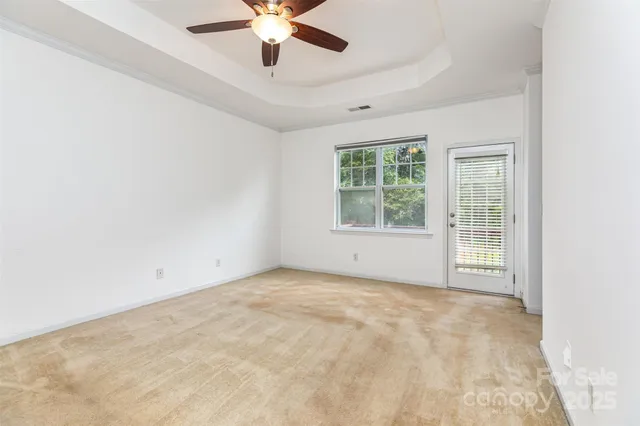 an empty room with a window and a ceiling fan
