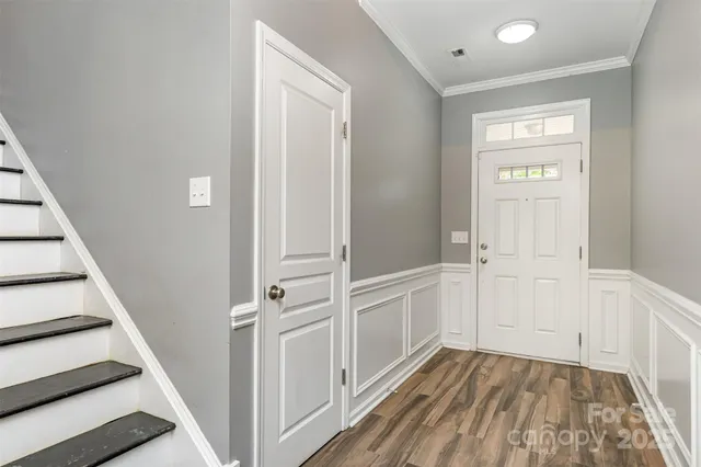 a view of a hallway with wooden floor and entryway