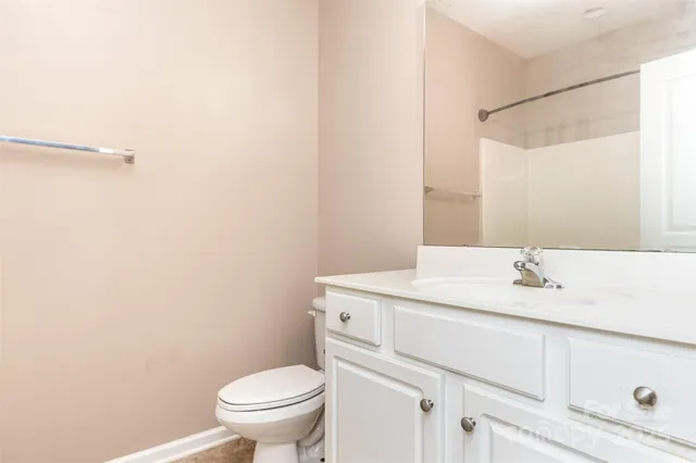 a bathroom with a granite countertop sink toilet and a mirror